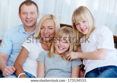 Portrait of happy family with twin daughters smiling at camera