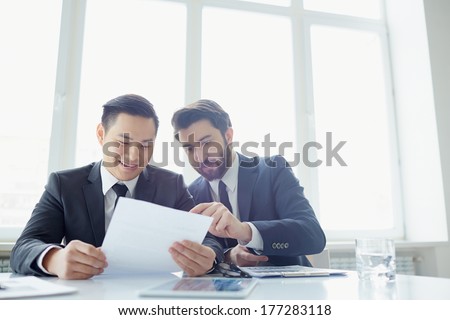Two managers discussing contract in meeting room