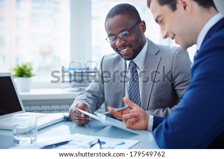 Image of two young businessmen interacting at meeting in office Image of two young businessmen interacting at meeting in office
