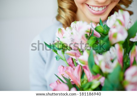Close-up of smiling female smelling pink flowers