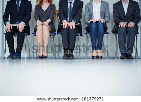 Several business people sitting on chairs in a row