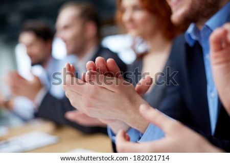Photo of business partnersÃ?ÃÂ¢?? hands applauding at the meeting