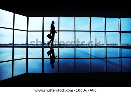 Outline of office worker with briefcase walking along window