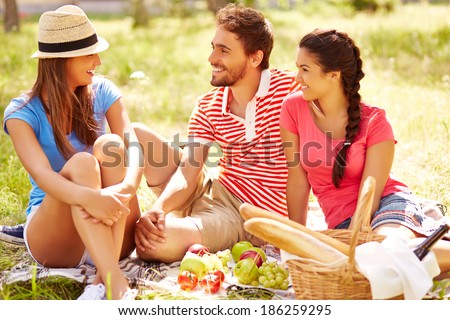 Happy young friends having picnic in the country
