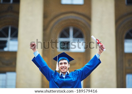 Portrait of confident student with graduation certificate showing gladness