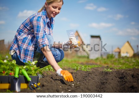 Image of female farmer sowing seed in the garden