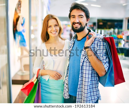 Portrait of young couple looking at camera in the mall