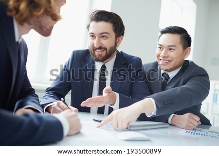 Two businessmen welcoming their new partner to sign contract