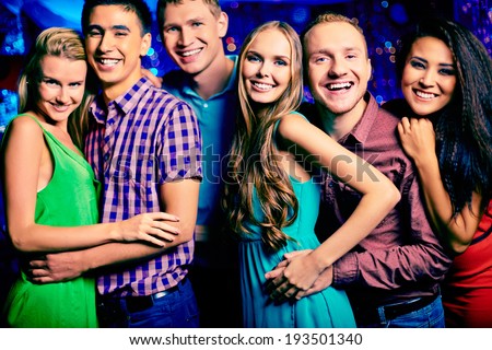 Portrait of happy friends looking at camera at party