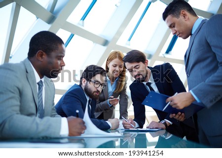 Group of business people discussing data or planning work at meeting