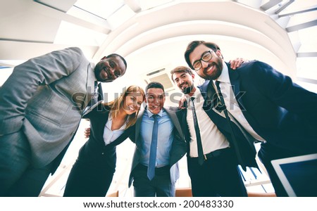 Group of successful business people in suits looking at camera