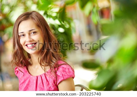 Portrait of an attractive young woman with a charming smile wearing fuchsia pink