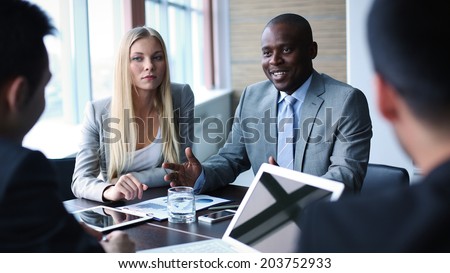 Image of businessman explaining his point of view to colleagues at meeting