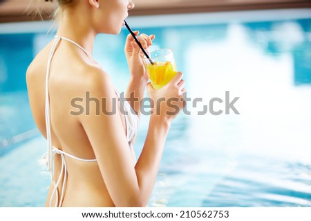 Girl drinking lemonade in swimming pool