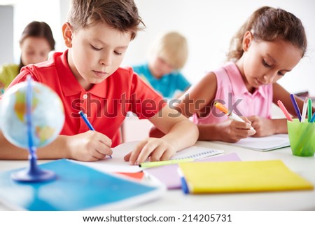 Junior pupils drawing with multi-color highlighters at lesson