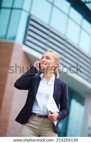 Portrait of elegant businesswoman speaking on the cellular phone outside