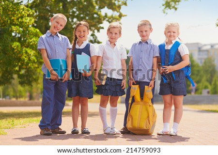 Several kids in school uniform outside