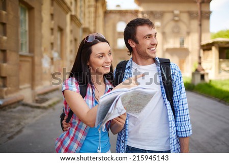 Couple of travelers with map deciding where to go sightseeing