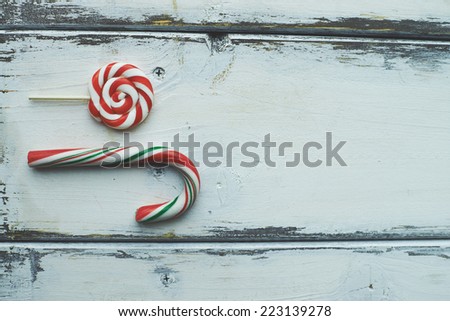 Sweet lollipop and sugar cane on white wooden background