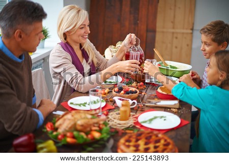 Portrait of modern family of four having festive dinner on Thanksgiving day
