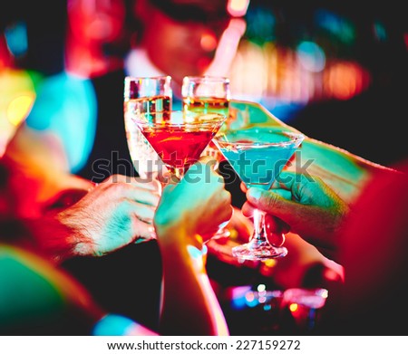 Hands of friends with cocktails making toast at party