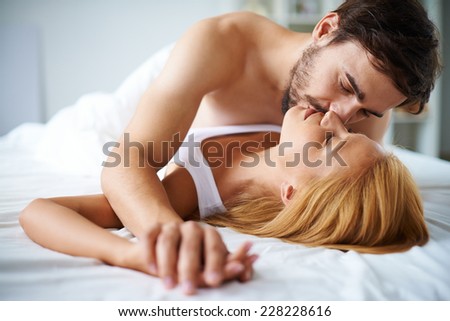 Amorous couple cuddling in bed