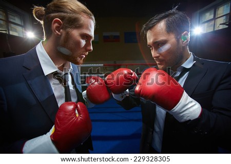 Angry men in suits and boxing gloves attacking one another