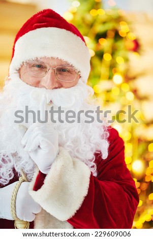 Happy Santa Claus in costume and eyeglasses looking at camera