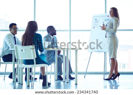 Woman showing financial charts to her colleagues