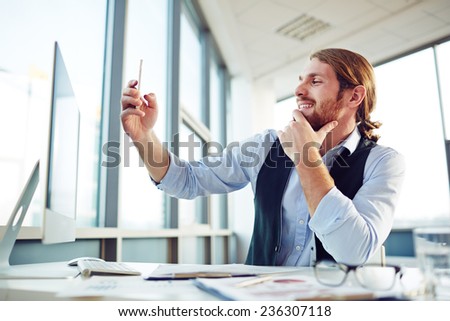 Happy employee making selfie during work in office