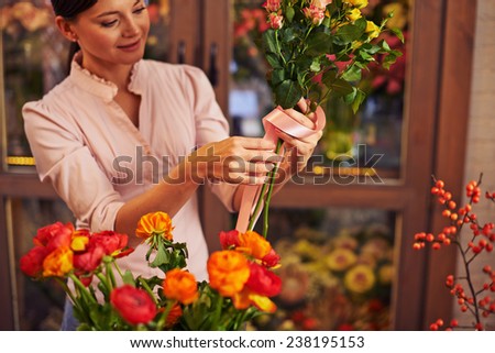 Female florist tying roses up with ribbon