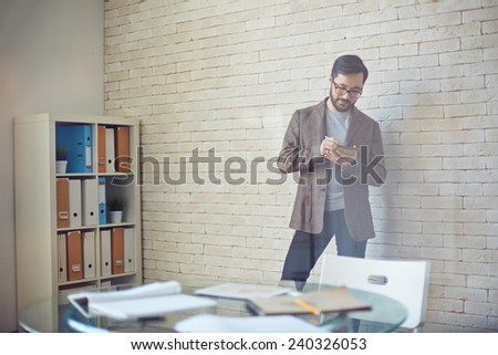 Young businessman writing plan of work in office