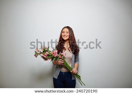 Happy lady with bunch of flowers looking at camera