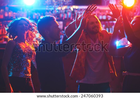 Young friends dancing by the bar counter at party