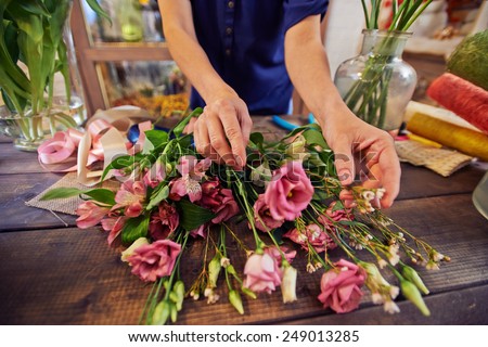Female florist working with flowers in workshop