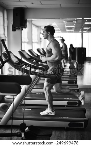Young man training on sport facilities in gym