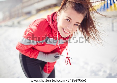 Girl with mobile phone looking at camera during outdoor training