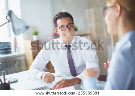 Happy businessman listening to his partner at coffee break