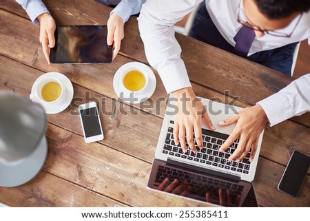 Hands of businesspeople during work with multi-media gadgets