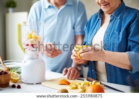 Senior people peeling fruits for smoothie