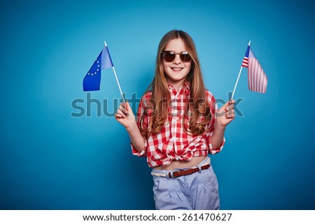 Nice girl keeping European Union and American flags on a stick