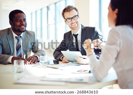 Smiling colleagues discussing working ideas in office