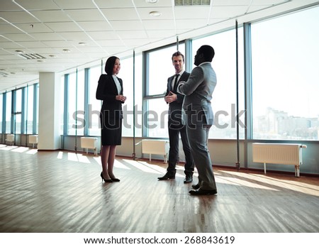 Group of elegant colleagues discussing plans in office