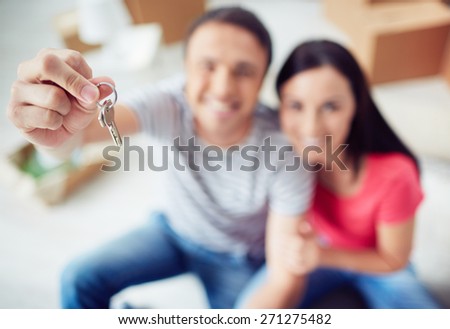 Young couple showing key from new apartment