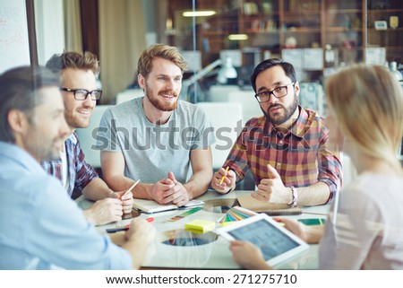 Group of confident managers listening to female employee