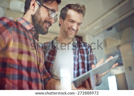 Modern businessmen with touchpad working with electronic documents