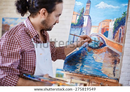 Young artist painting Italian landmark in studio