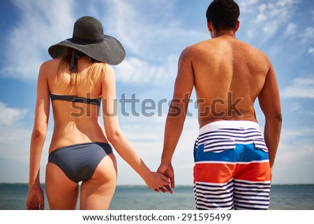 Restful couple in swimwear spending vacation by the sea