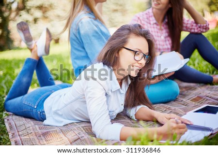 College student making notes in notepad outdoors