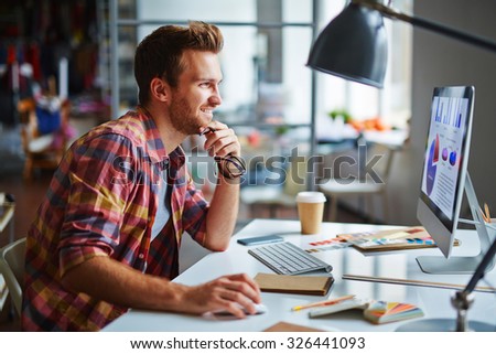 Happy man looking at computer screen with data while making final decision